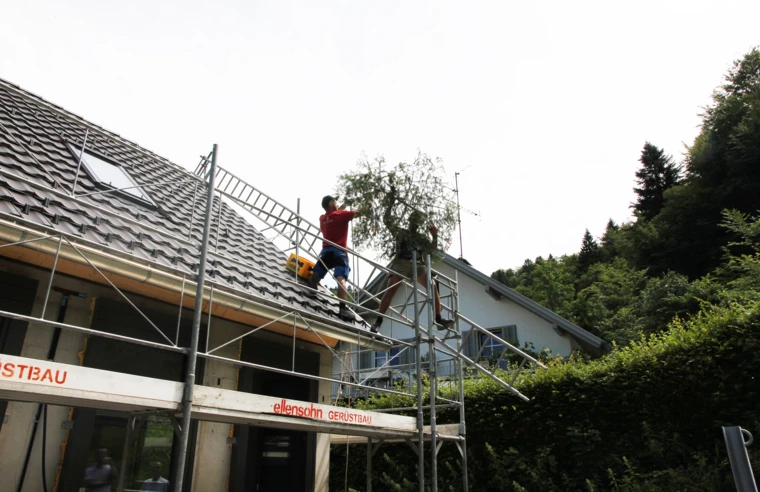 Handwerker beim Aufziehen des Firstbaumes auf den Rohbau der Wohnanlage im Dornbirner Eulental. Handwerker beim Aufziehen des Firstbaumes auf den Rohbau der Wohnanlage im Dornbirner Eulental.